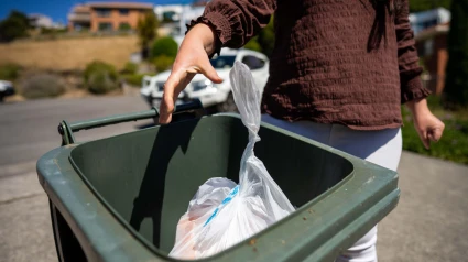 Mujer tirando algo a la basura