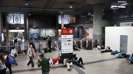 Imagen de la estación de tren de Atocha, en Madrid, donde cientos de pasajeros esperan pasar la noche hasta que se reanude la circulación de trenes tras el apagón eléctrico que se ha producido hoy lunes en la Península Ibérica